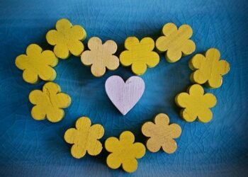 Blue background with yellow flowers in the shape of a heart mirroring the colours of the Ukrainian flag