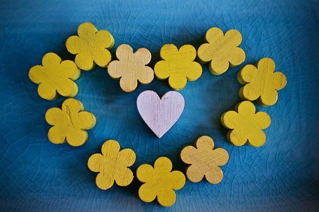 Blue background with yellow flowers in the shape of a heart mirroring the colours of the Ukrainian flag
