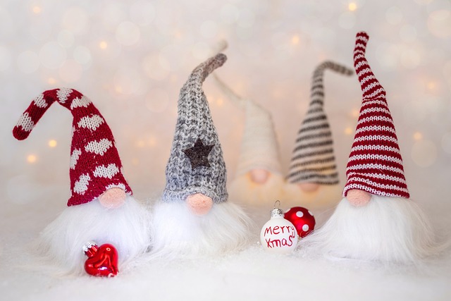 Four christmas gnomes in hats with a christmas bauble that reads merry xmas